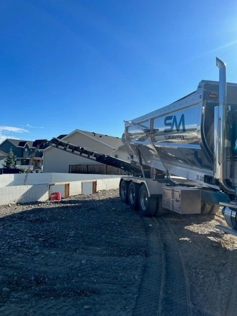 Stone slinger boom placing material at a residential site