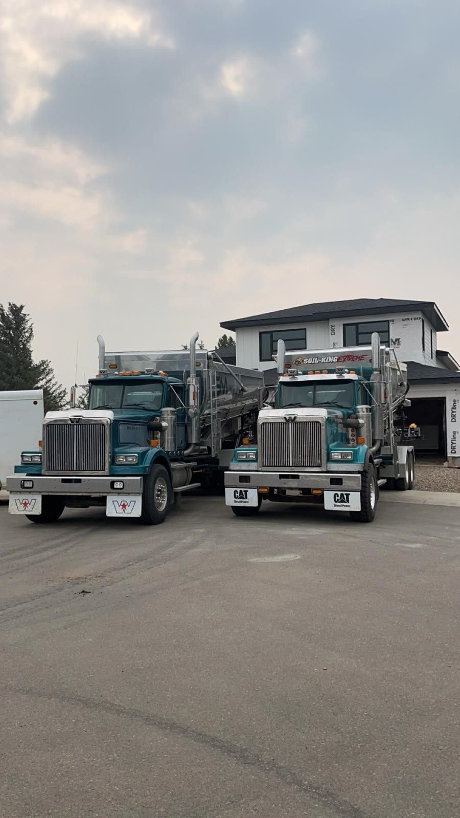 Two Sling Master stone slinger trucks parked side by side